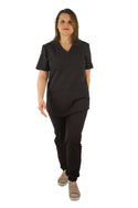 Pro Stretch Kasack für Damen Active in Braun – dynamische Pose mit Vorwärtsschritt, inklusive passender Hose. Flexible, atmungsaktive Arbeitskleidung für medizinisches Fachpersonal.